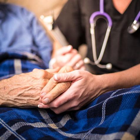 Patient and caregiver holding hands
